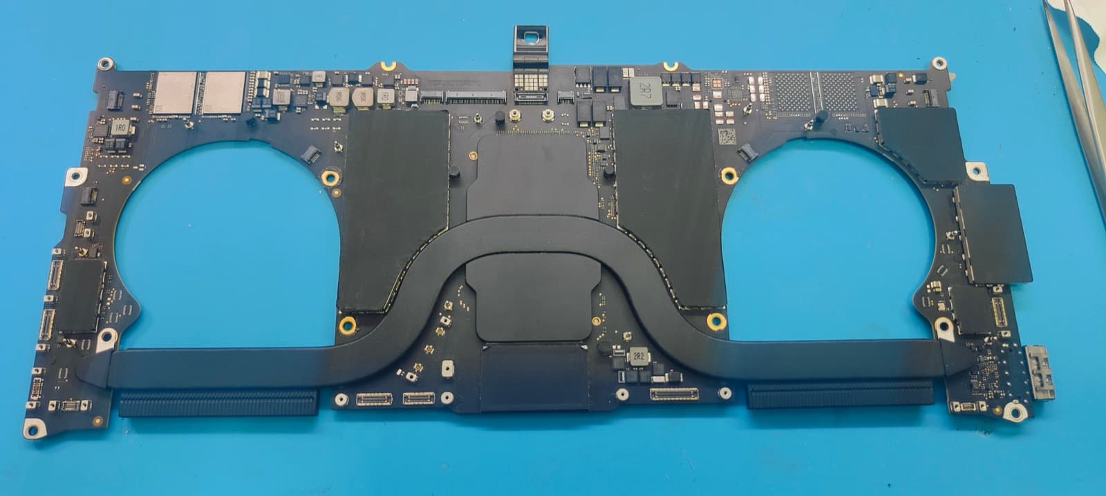 Underside of the repaired MacBook Pro M1 A2442 logic board after the charging section component replacement